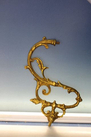 Tres apliques, tiradores, asas o adornos de bronce o latón.