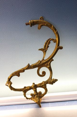 Tres apliques, tiradores, asas o adornos de bronce o latón.