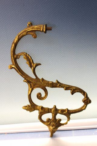 Tres apliques, tiradores, asas o adornos de bronce o latón.