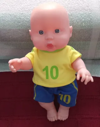 Muñeco bebé con camiseta amarilla y pantalón corto