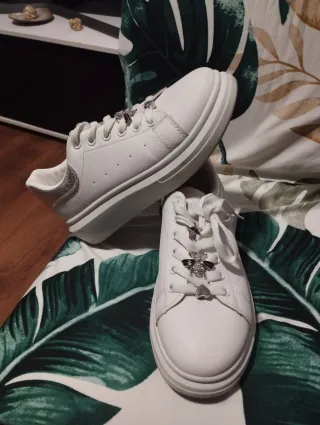 Zapatillas blancas con adornos plateados