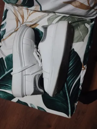 Zapatillas blancas con adornos plateados