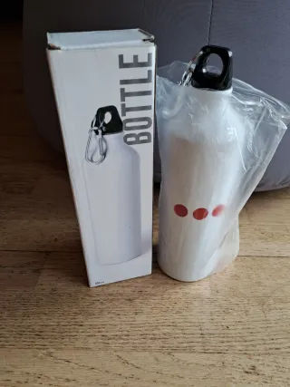 Botella de agua blanca con puntos rojos