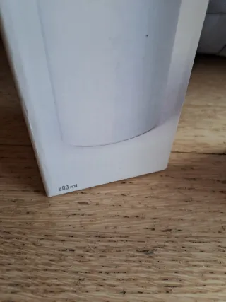 Botella de agua blanca con puntos rojos