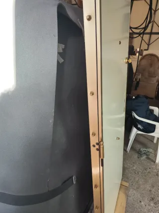 Puerta blindada blanca con marco dorado