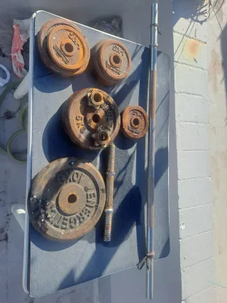 Discos y barra de gimnasio oxidados