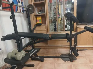 Banco de pesas con barra y mancuernas