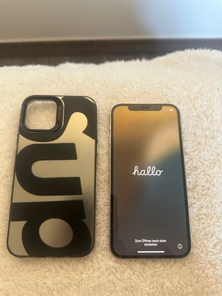 iPhone 12 Pro bianco, con custodia e cavo caricatore.