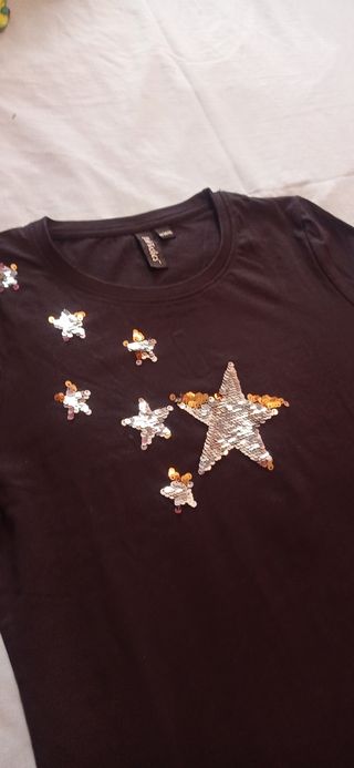Camiseta negra con estrellas doradas y plateadas
