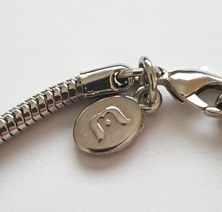 Braccialetto con 4 charmes e due fermi in acciaio