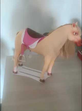 Caballo de juguete con montura rosa