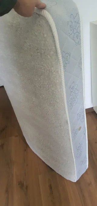 Cuna de madera y colchón.