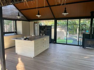 Pérgola acristalada con chimenea y buhardilla