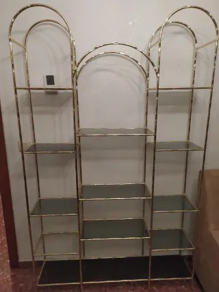 Estantería dorada con baldas de cristal