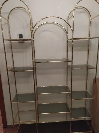 Estantería dorada con baldas de cristal