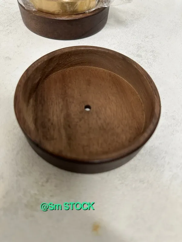 Cenicero de madera de nogal con un diseño elegante y un toque decorativo. Incluye una tapa y un pequeño adorno. - Material: Madera de nogal y metal. - Color: Marrón oscuro y dorado. - Diseño: Cil...