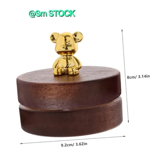 Cenicero de madera de nogal con un diseño elegante y un toque decorativo. Incluye una tapa y un pequeño adorno. - Material: Madera de nogal y metal. - Color: Marrón oscuro y dorado. - Diseño: Cil...