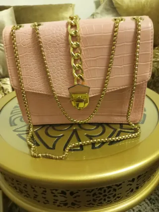 Bolso de mano rosa con cadena dorada