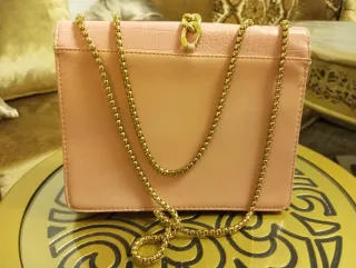 Bolso de mano rosa con cadena dorada