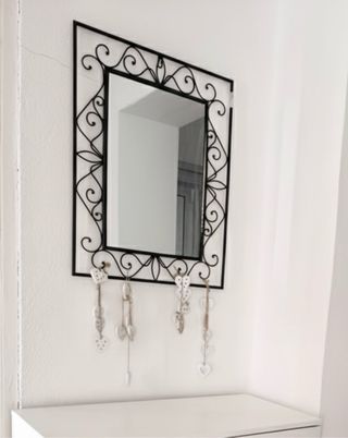 Specchio di metallo con cornice decorata