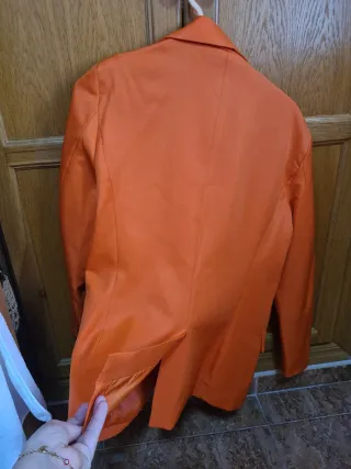 Blazer naranja tiene hombreras y forro