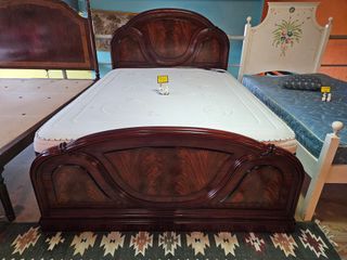 Cama de madeira escura com colchão