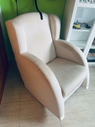Sillón balancín tonos beige y blanco.