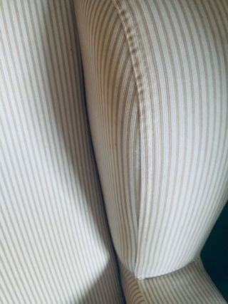 Sillón balancín tonos beige y blanco.