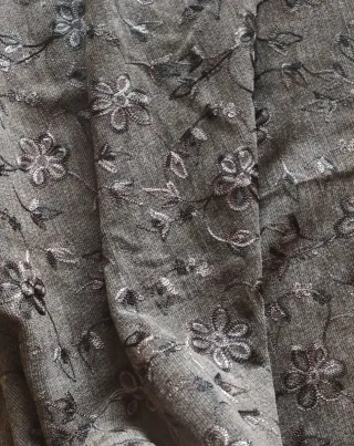Tela gris con bordado floral. 120m de confección