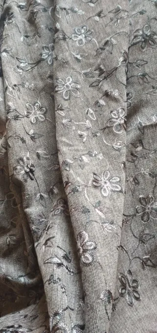 Tela gris con bordado floral. 120m de confección