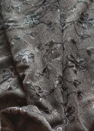 Tela gris con bordado floral. 120m de confección