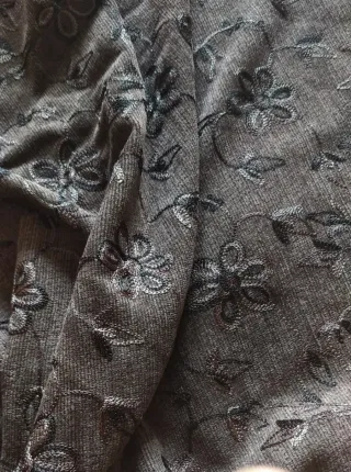 Tela gris con bordado floral. 120m de confección