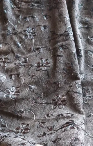 Tela gris con bordado floral. 120m de confección