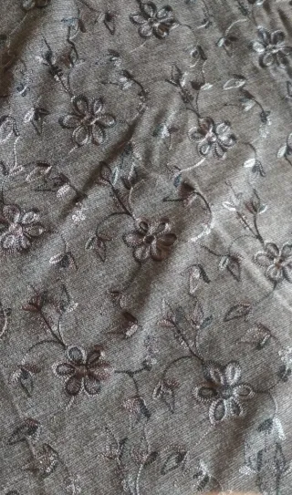 Tela gris con bordado floral. 120m de confección