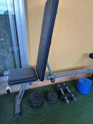 Banco multifuncional con mancuernas y discos