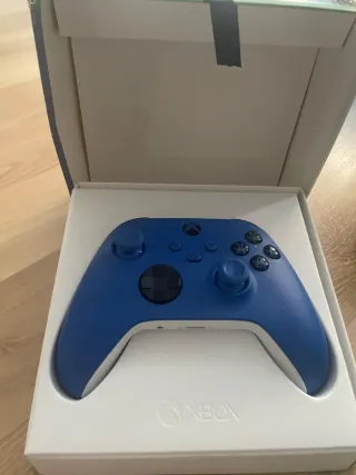 Consola Xbox Series X in nero con controller aggiuntivo blu e base di raffreddamento