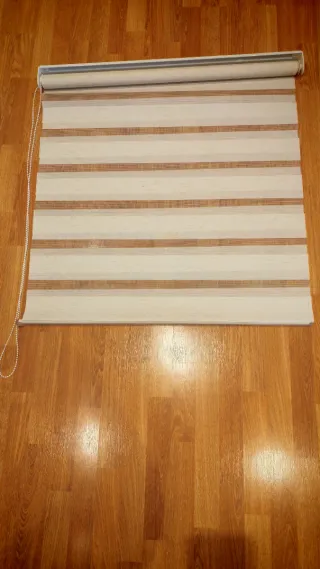 Tenda a rullo a righe beige e trasparente.