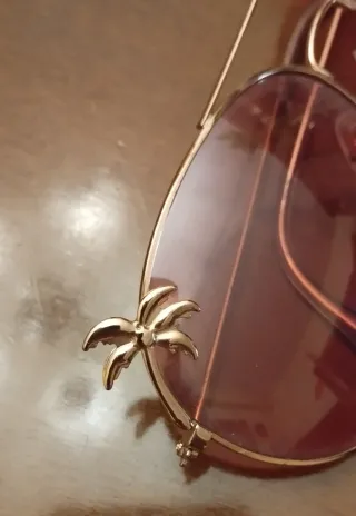 Gafas de sol rosas con montura dorada de palmeras
