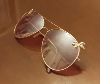 Gafas de sol rosas con montura dorada de palmeras