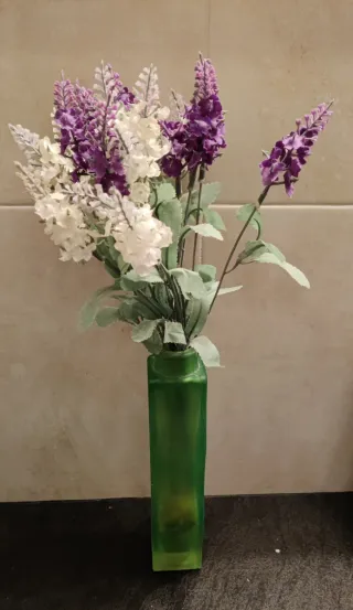 Florero de cristal verde con flores