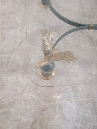 Mesa de forja con cristal y águilas en las patas,