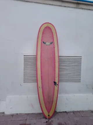 Tabla de surf rosa y amarilla