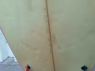 Tabla de surf rosa y amarilla