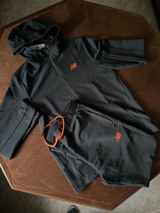 Conjunto deportivo New Balance negro y naranja.