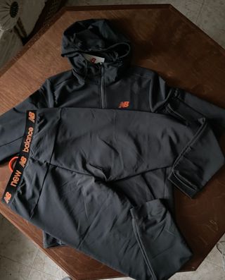 Conjunto deportivo New Balance negro y naranja.