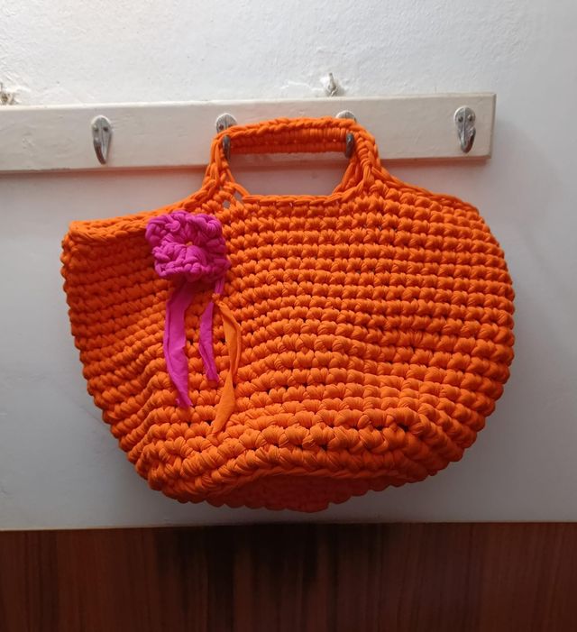 Bolso de crochet naranja con flor rosa