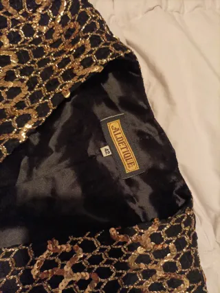 Vestido fiesta lentejuelas dorado, negro chaqueta.