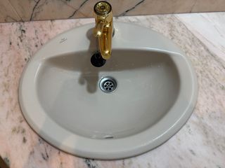 Lavabo de mármol con grifo dorado