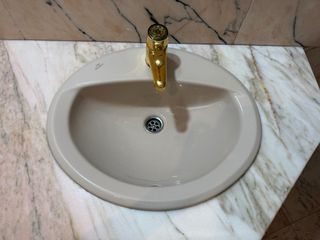Lavabo de mármol con grifo dorado
