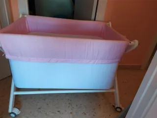 Minicuna con ruedas y vestidura rosa